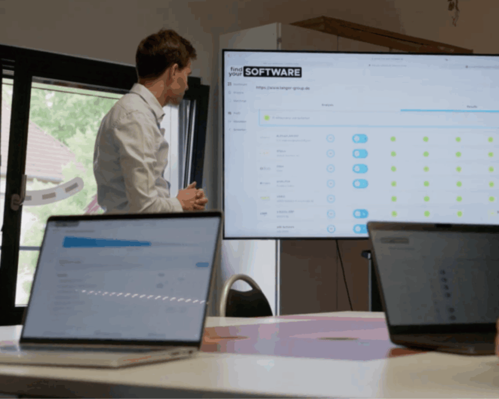 Dr. Benedict Bender, Tim Körppen und Dr. Marcel Panzer testen die Find-your-Software Matching Engine auf zwei MacBooks.
